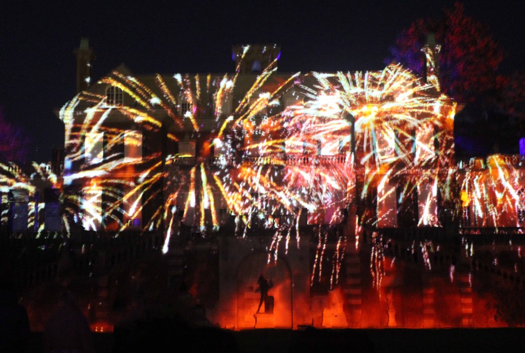 Mansion at night illuminated with fireworks.