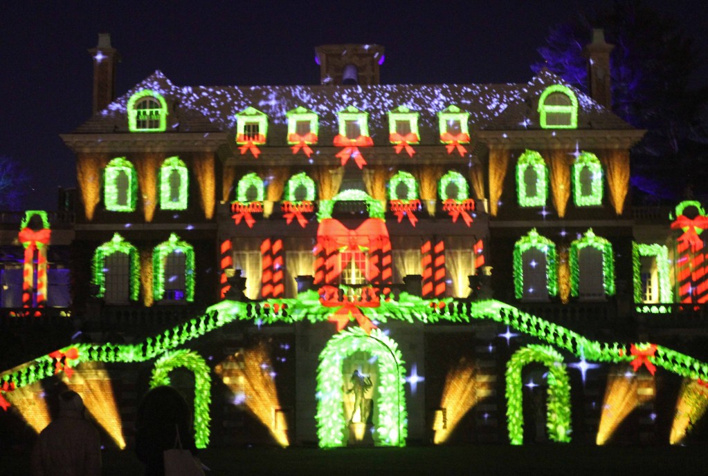 Mansion at night illuminated with red and green lights.