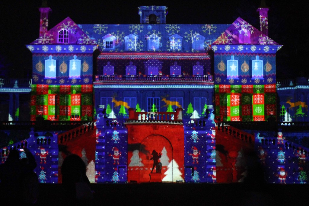 Mansion at night illuminated with Christmas holiday lights.
